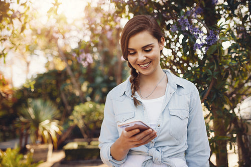 Woman using mobile phone in a garden