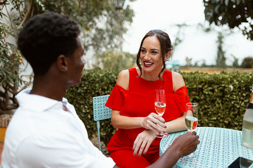 Happy couple enjoying sparkling wine in their backyard