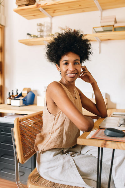 Happy woman at work desk in jewelry studio
