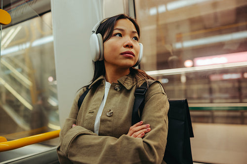 Woman with headphones commuting on a city metro