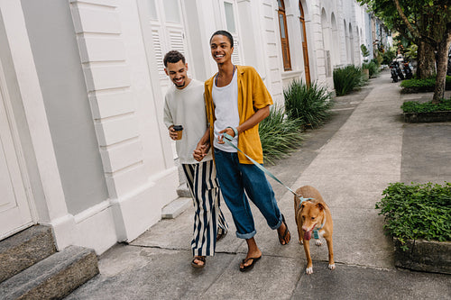 Couple walking their dog in a modern residential neighborhood