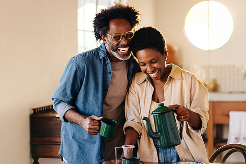 Happy Brazilian wife serving coffee for breakfast with her husband