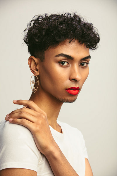 Transgender male with make staring at camera