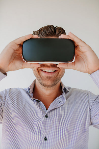 Young man using VR goggle and smiling.