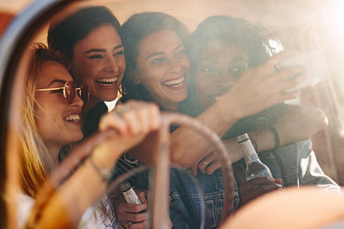 Young friends taking selfie in the car