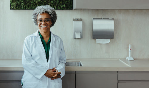 Lab coat dentist standing in clean dental clinic interior