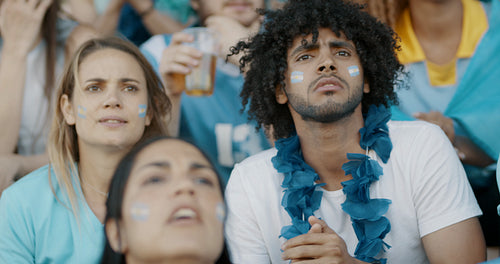 Anxious fans in crowd expressing disappointment during game