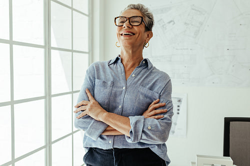 Career success: Female design architect stands in her office with a happy smile