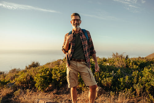 Male hiker smiling at the camera at sunset