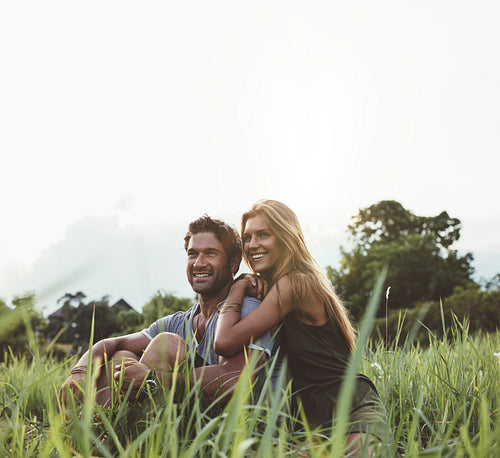 Loving couple sitting on grass field