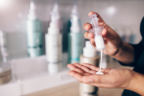 Closeup of woman pouring shampoo on palm