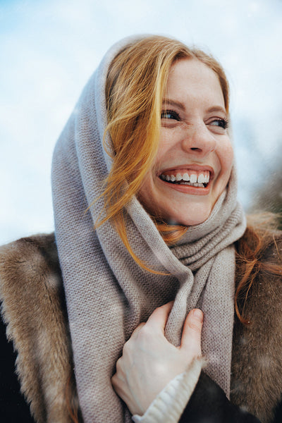 Scarf-holding woman poses for winter fashion outdoors