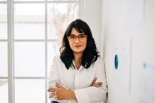 Business woman looking at the camera as she stands in an office