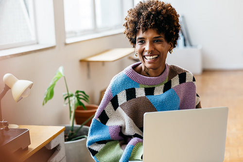 Smiling woman working on laptop in a co-working space