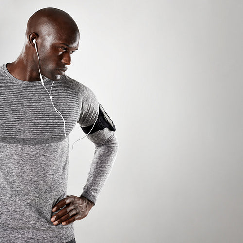 Tough young guy with earphones staring at copy space