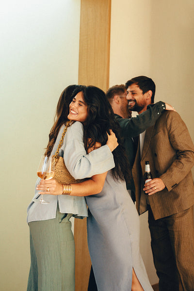 Friends greeting and embracing at a casual social gathering