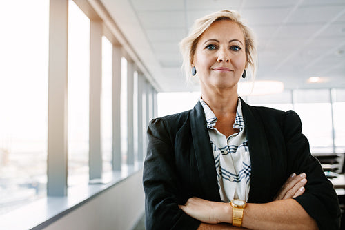 Confident mature businesswoman standing in office