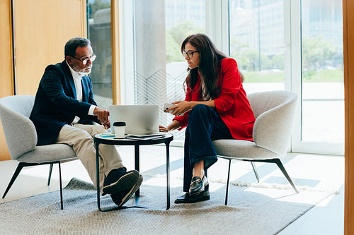 Senior business professionals discussing ideas during a meeting in a bright office