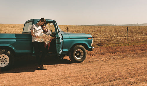 Couple on a road trip looking at map for navigation