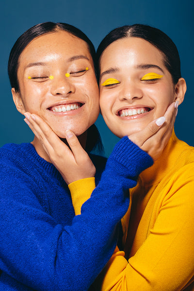Generation Z and makeup: Happy young women wearing yellow eyeshadow and eyeliner