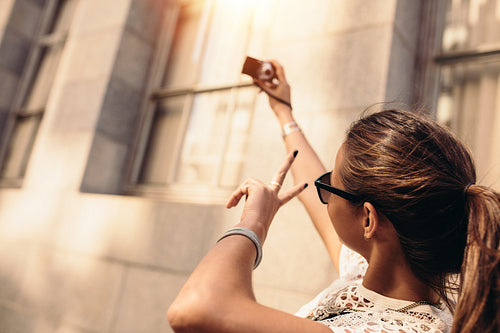 Young tourist recording selfie while walking in the street.