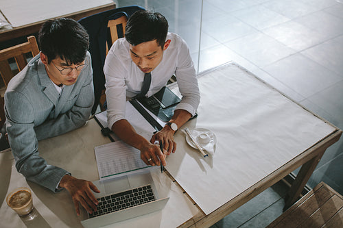 Asian businessmen meeting in coffee shop using laptop