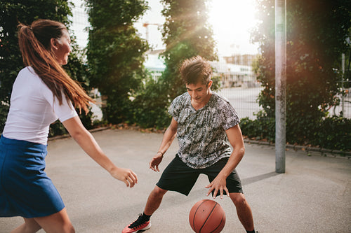 Friends playing basketball on court and having fun