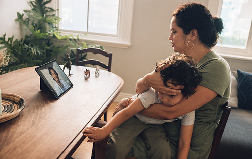 Mother with her sick son video calling online doctor