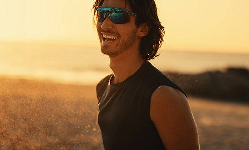 Female beach volleyball champion celebrating victory on sandy seashore at sunset