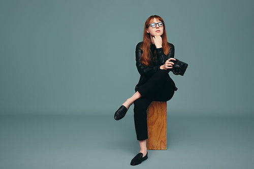 Young photographer looking at the camera in a studio