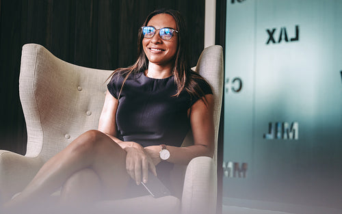 Happy young businesswoman smiling in her office