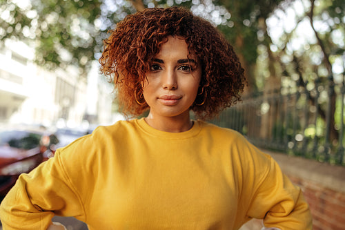 Self-confident teenage girl standing with her hands on her hips