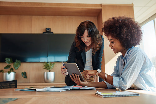 Professional employees discussing project on tablet pc