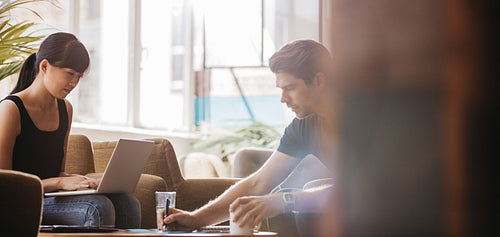 Two young businesspeople sitting together in a cafe