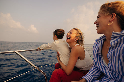 Grandmother enjoying luxury vacation on yacht with laughing daughter and grandchild
