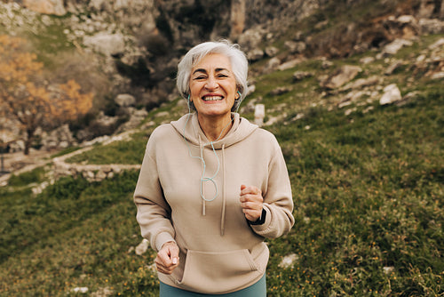 Happy elderly woman working out outdoors