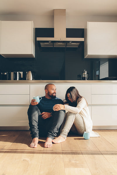 Loving couple enjoying a coffee on kitchen floor