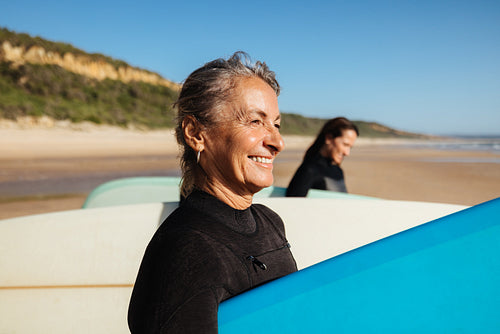Joyful women enjoying a surfing experience on a sunny beach day