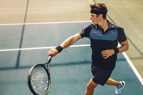 Tennis player returning the serve with a powerful forehand