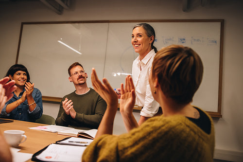 Business team appreciating effort of coworker in meeting