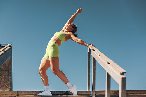 Energetic sporty woman in her 30s having fun exercising outdoors in daylight
