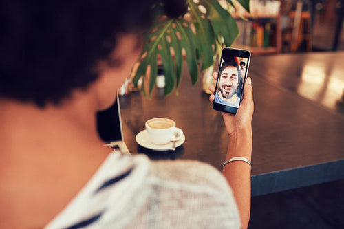 Woman having a videochat with friend on mobile phone.