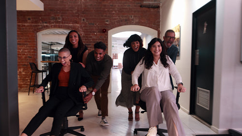 Business colleagues celebrate their success over a playful break in the office