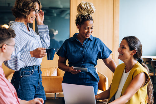 Group of coworkers happily interacting in a modern workspace