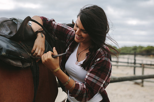 Woman getting her horse ready for a ride