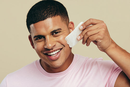 Beauty with a gua sha stone: Man massaging his face for a healthier skin