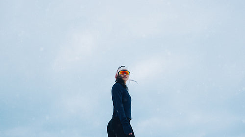 Strong woman athlete poses confidently in snowy winter landscape