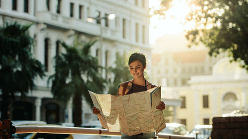 Woman standing outdoors holding a map