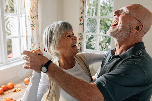 Senior couple laughing and having fun dancing