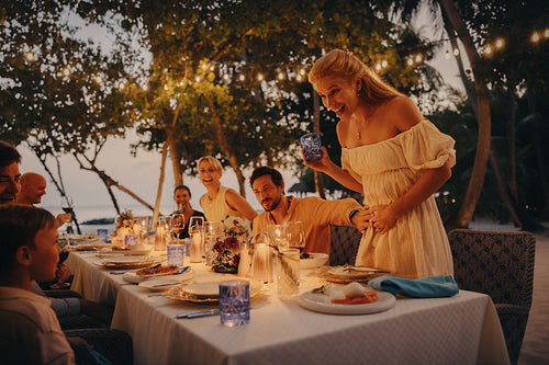 Family celebrating pregnancy announcement during dinner at tropical resort